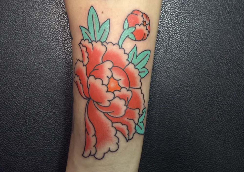 Red Japanese peony tattoo with a bud and green leaves on the forearm